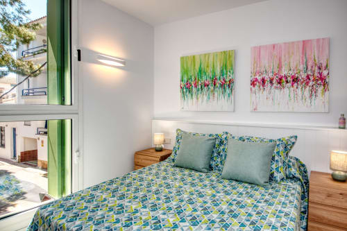 Dormitorio moderno en Finques Garcia Enrich en Palafrugell con obras de arte coloridas y ropa de cama geométrica