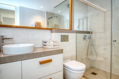 Baño moderno en Finques Garcia Enrich en Palafrugell con lavabo tipo vasija, ducha a ras de suelo y elegantes detalles de madera