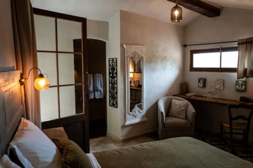 Schlafzimmer La Chapelle im La Bouscatière B&B in Moustiers-Sainte-Marie mit Bett, Schreibtisch, Spiegel und warmem Licht