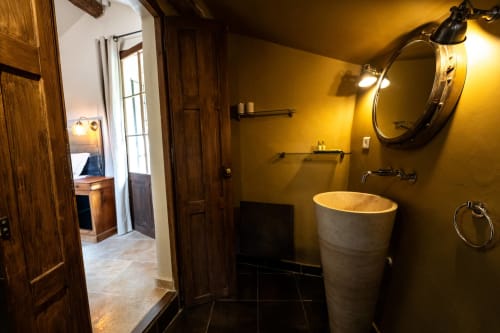 Modernes Badezimmer im La Chapelle Zimmer des La Bouscatière B&B in Moustiers-Sainte-Marie mit senfgelben Wänden und zylindrischem Stein