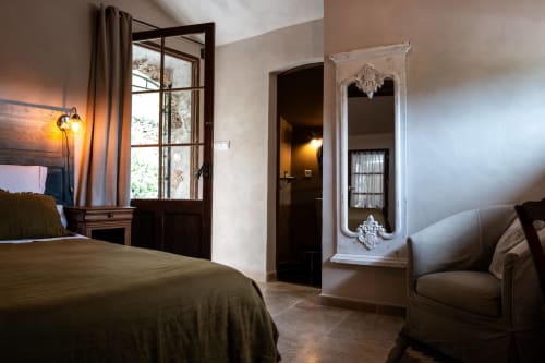 Elegantes Schlafzimmer im La Bouscatière B&B in Moustiers-Sainte-Marie mit Olivenbettwäsche, Glastüren und klassischer Einrichtung