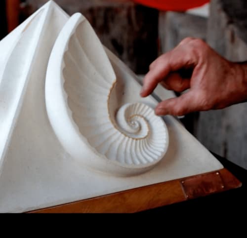 Hand showcasing white spiral seashell sculpture at La Cachette d'Oona, Saint-Jean-de-Monts B&B