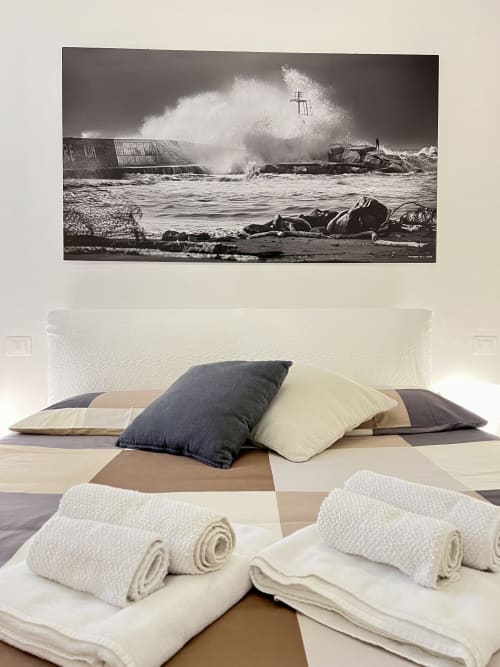 Camera da letto con vista costiera alla LA Home Puzzle House di Viareggio, con opera d'arte ondata di tempesta sopra il letto, cuscini e asciugamani