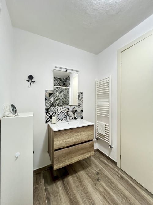 Bagno moderno nell'appartamento La Home Puzzle House, Viareggio. Vanity in legno, piastrelle decorative, specchio, scaldasalviette