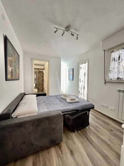 Camera da letto moderna della LA Home Puzzle House a Viareggio con letto matrimoniale, pavimento in legno e vista sulla città