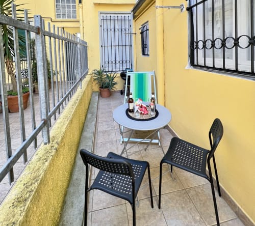Luminosa terrazza gialla dell'appartamento a Viareggio con sedie nere, tavolo rotondo e vista mare presso l'hotel LA Home