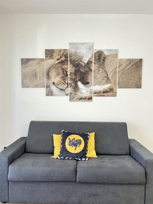 Divano grigio con cuscino giallo sotto un'opera d'arte raffigurante un leone nel living room dell'appartamento LA Home, Viareggio