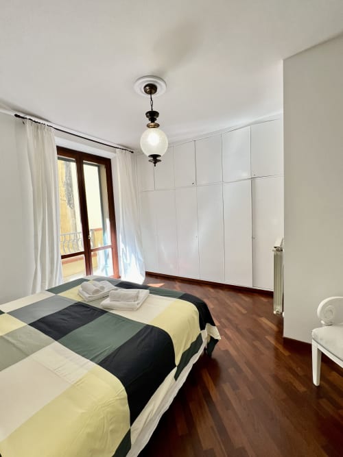 Spaziosa camera da letto dell'appartamento LA Home a Viareggio con letti gemelli, armadi bianchi e accesso al balcone