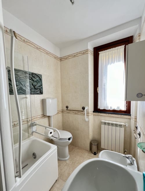 Bagno accessibile nell'appartamento LA Home a Viareggio con doccia, WC, bidet e maniglie di sostegno
