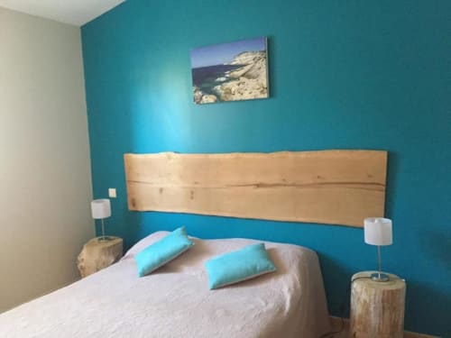 Chambre côtière Vista D'oro aux murs turquoise, lit en bois, vue mer et coussins assortis