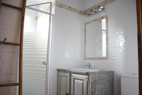 Salle de bains moderne de l'hôtel Vista D'oro à Monacia d'Aullène avec vasque, miroir, douche et carrelage blanc