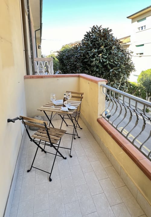 Balcone dell'appartamento a Viareggio con tavolo da pranzo, sedie e vista sulla città presso LA Home Hotel