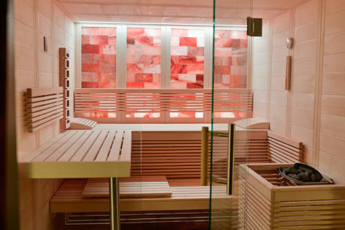 Modern sauna with wooden benches and red chromotherapy lights at Pavillon Des Millesimes SPA, Lussac