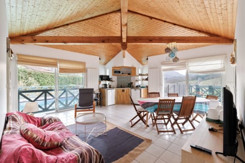 Chambre spacieuse avec vue montagne à Villa Ongizatea, plafond voûté en bois, kitchenette, coin repas et salon