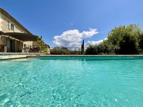 Turquoise zwembad van boutique B&B Provence Km28 in Gordes met stenen villa en cipressen