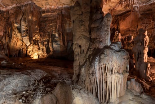 Stalattiti e stalagmiti nella camera illuminata di una grotta vicino a Le Martinet, Francia