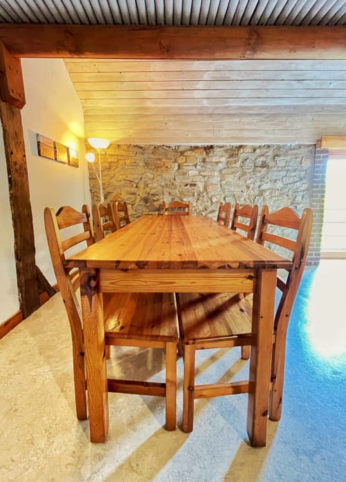 Table en bois rustique avec chaises dans un appartement aux murs en pierre à La Ferme De Werpin, Hotton