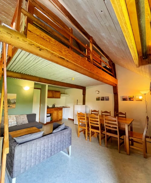 Spacieux séjour à La Ferme De Werpin avec poutres apparentes, table à manger, kitchenette et places pour 7 personnes