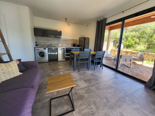 Modern 1-bedroom villa at Villas Lantana Lecci with open-plan kitchen, dining area, living space and terrace access