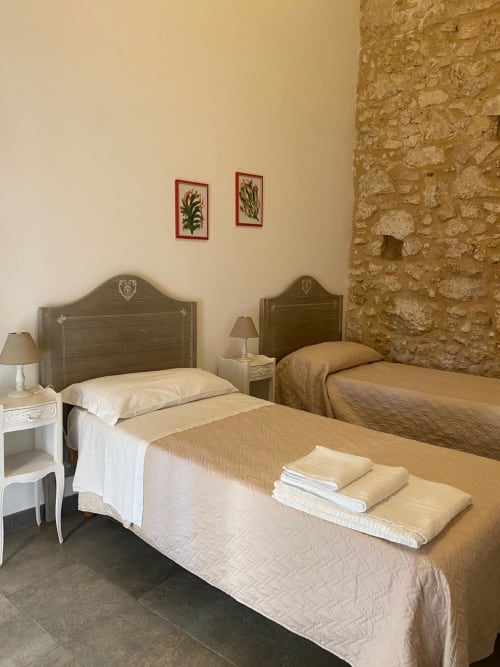 Camera matrimoniale a Corte Sicula B&B a Siracusa con muri in pietra e arredamento rustico