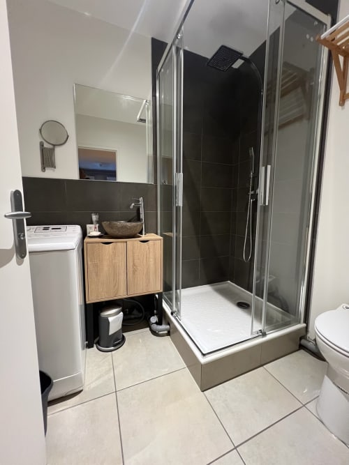 Salle de bain moderne aux Couleurs Montagne, Valloire avec douche vitrée, meuble vasque en bois et carrelage noir