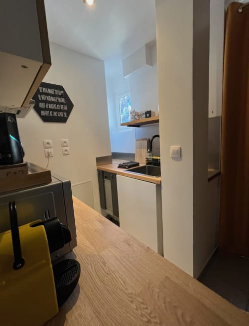 Cuisine de l'appartement Jaune Génépi à Valloire avec équipements modernes, coin repas et vue sur les montagnes à l'hôtel Couleurs Montagne