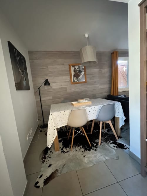 Coin repas cosy de l'appartement Jaune Génépi à Couleurs Montagne, Valloire avec nappe à pois et bureau en bois