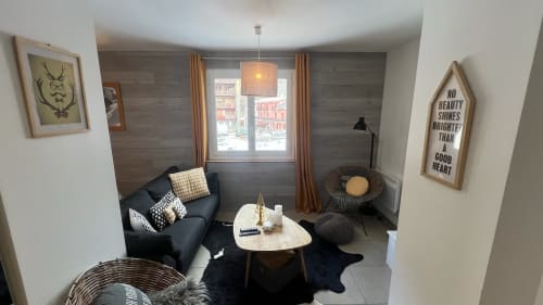 Salon moderne de l'appartement Couleurs Montagne à Valloire avec canapé noir, table ronde et vues sur les montagnes