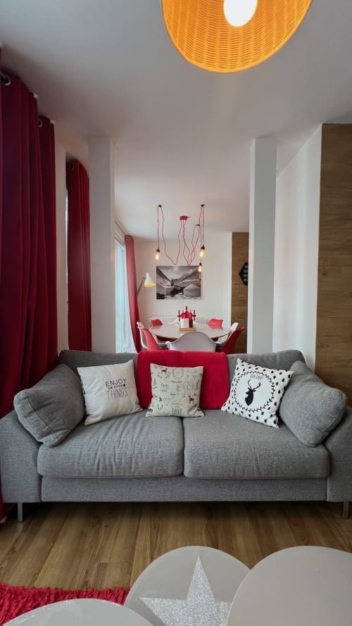 Appartement Couleurs Montagne Rouge Canneberge à Valloire avec canapé gris, accents rouges et coin repas