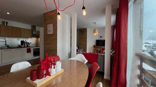 Coin repas de l'appartement Rouge Canneberge à Couleurs Montagne, Valloire, avec accents rouges et vue sur les montagnes