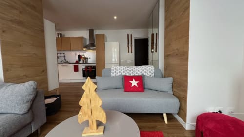 Séjour cosy à Couleurs Montagne, Valloire avec canapé gris, décoration en bois et cuisine au fond