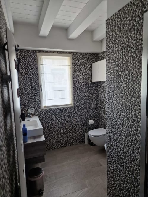 Bagno moderno nella Luxury Room & Private SPA Rio Botteniga di Treviso con rivestimenti in pietrisco scuro, lavabo bianco, wc e