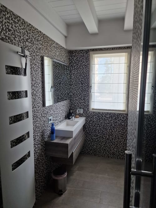 Bagno moderno nella Rio Botteniga Luxury Room & Private SPA di Treviso con rivestimento a mosaico e mobile lavabo sospeso