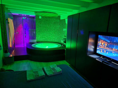 Lussuosa suite spa a Rio Botteniga con vasca idromassaggio circolare illuminata al neon, doccia e area intrattenimento a Treviso