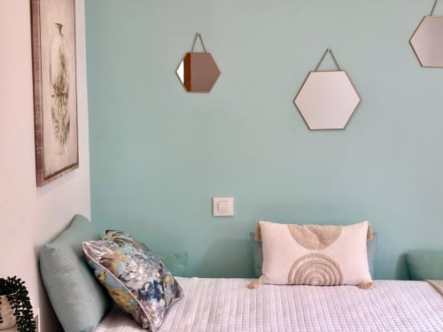 Dormitorio moderno en cottage Laranxeira con paredes verde agua, espejos hexagonales y ropa de cama rosa cerca de Baiona