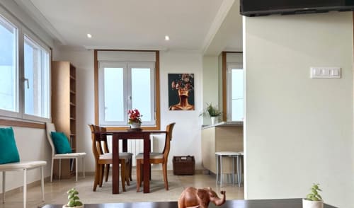 Luminoso comedor con vistas al mar en Nigrán: mesa de madera, detalles en azul verdoso y comodidades modernas