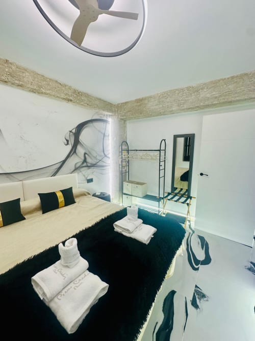 Dormitorio moderno en apartamento de Mérida con cama, almacenaje, ventilador de techo y vistas a la ciudad en hotel Gestyp-AT