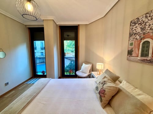 Dormitorio luminoso en apartamento de Baiona con vistas a la piscina, cama doble, balcones y comodidades modernas