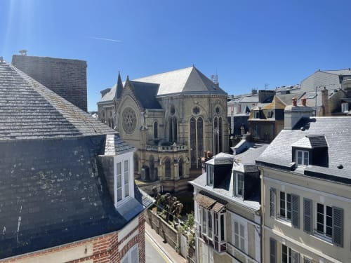 Gothic church surrounded by Parisian-style buildings in Trouville sur Mer, France from Hotel Le Trouville room view