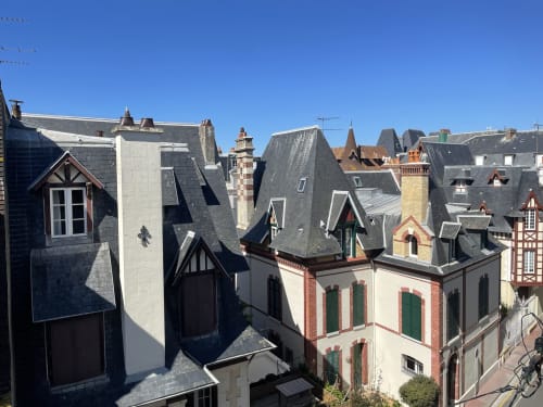 Rooftop view of historic Trouville-sur-Mer featuring traditional French architecture and mansard roofs at Hotel Le Trouville