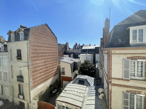 Aerial view of Hotel Le Trouville's courtyard in Trouville-sur-Mer with neighboring rooftops and buildings