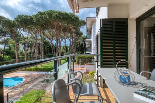 Balcony view at Finques Garcia Enrich apartment in Palafrugell with garden, pool, and Mediterranean pine trees
