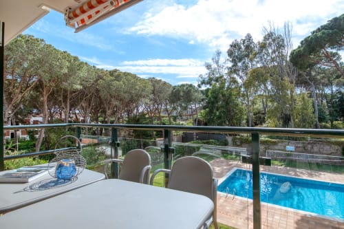 Balcony terrace overlooking shared pool and Mediterranean garden at Canadell apartment, Palafrugell