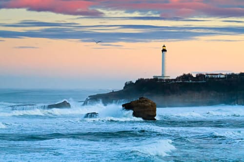 Faro costero al atardecer cerca de Villa Ongizatea, Urrugne Francia con olas y playas rocosas