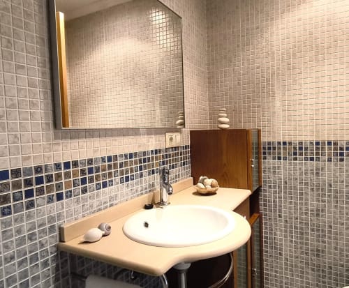 Baño moderno en apartamento Holibai, Baiona con paredes de azulejos en mosaico, lavabo redondo y espejo botiquín