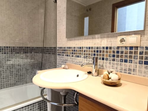 Baño moderno en apartamento Angelitiña, Baiona con lavabo redondo, azulejos mosaico decorativos y área de ducha