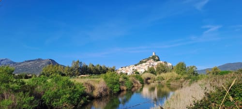 Il medievale villaggio di Posada affacciato sulla suggestiva valle fluviale sotto il cielo azzurro della Sardegna