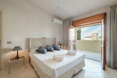 Camera luminosa a House Live Express a Quartu Sant'elena con letto queen, balcone e servizi moderni