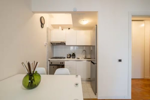 Cucina e zona pranzo compatta dell'hotel House Live Express a Quartu Sant'elena con mobili bianchi e elettrodomestici moderni