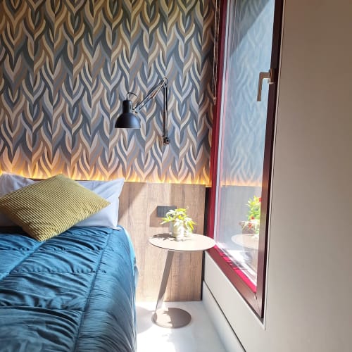 Modern bedroom at Locanda del Sasso in Crodo with blue bedding, patterned wallpaper, mountain view from balcony door